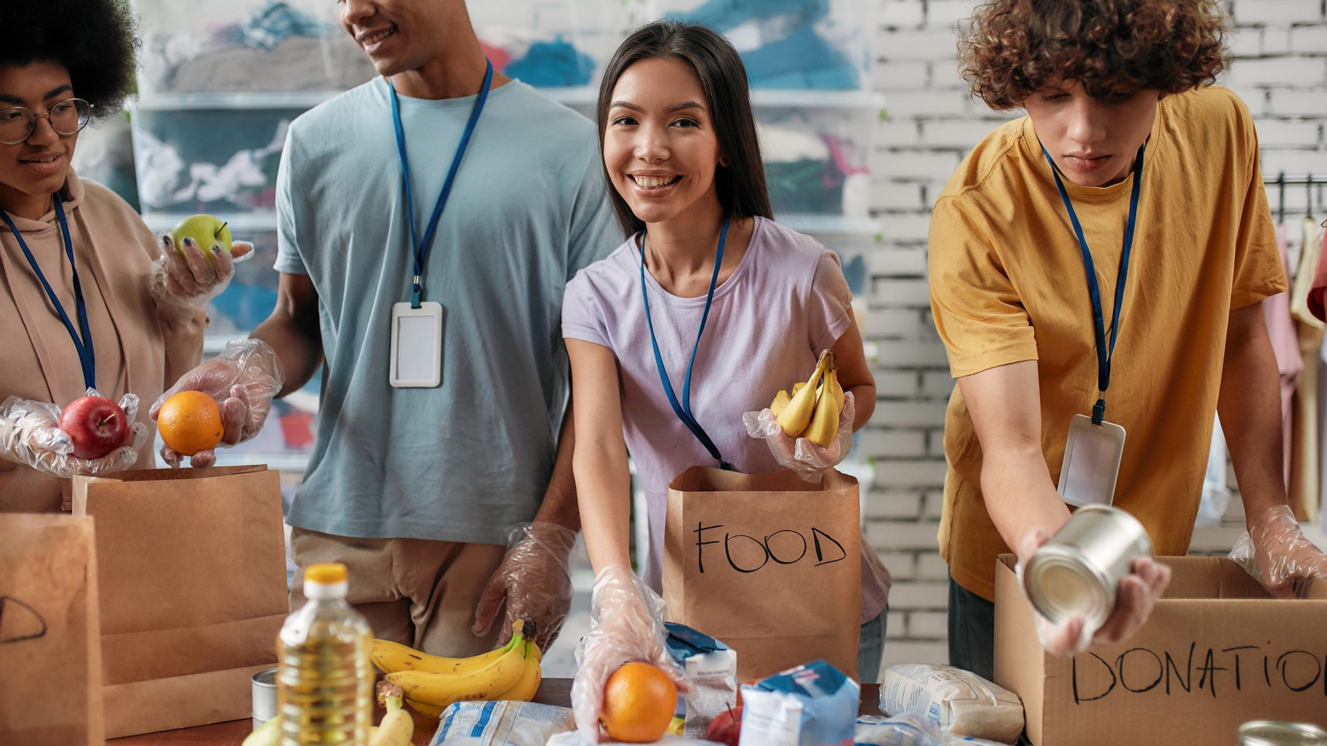 A group of individuals with name tags seem to be volunteering at a food drive, with one person holding a bag labeled 
